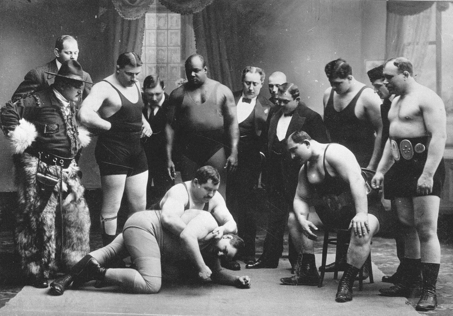 Группа участников чемпионата наблюдает за схваткой двух борцов СП 1912.jpg